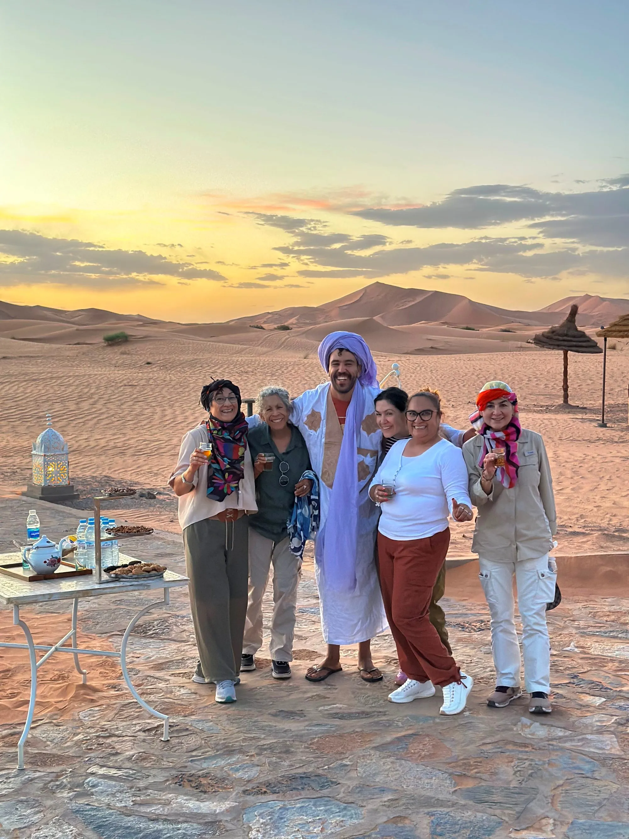A group of travellers with their guide at a Sahara sunset